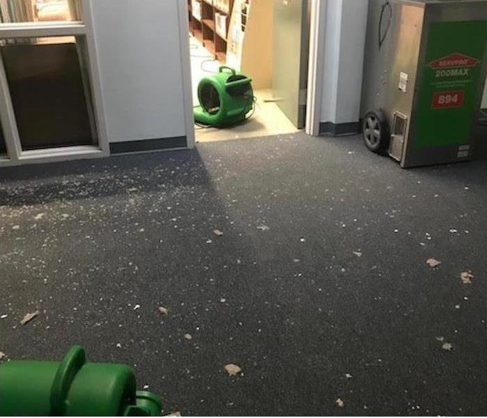 Gray carpet with debris and SERVPRO drying equipment  