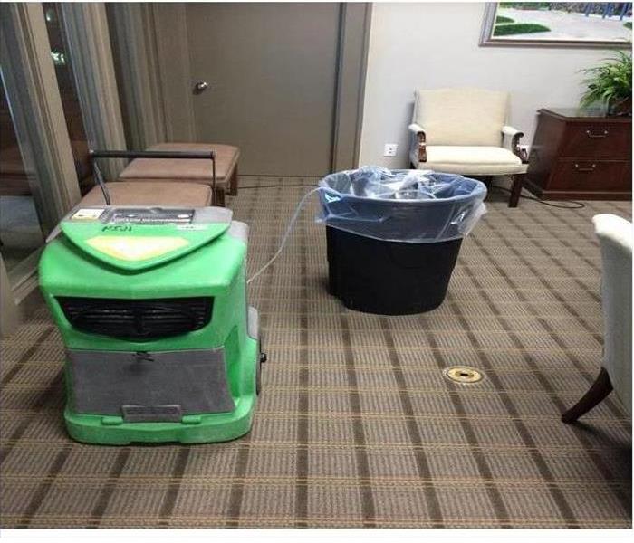 Carpet with SERVPRO dehumidifier and trash can  