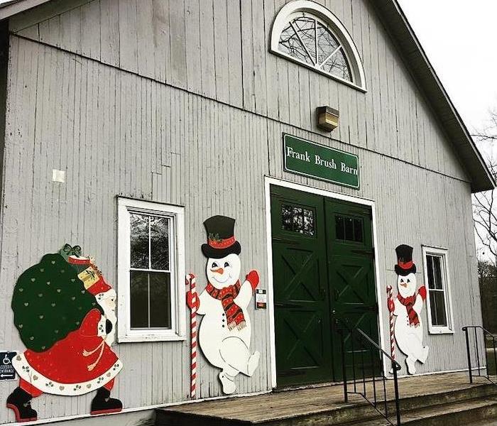 Grey barn with black doors, 2 snowmen and a Santa on the front
